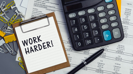 The words Work Harder written on a white notebook