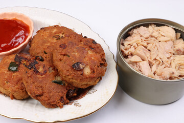 Tuna fish meat patty burger kebab with sauce on pate tuna flake chunk in tin can over white background