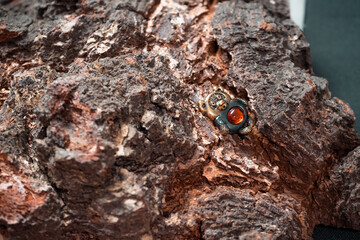 Decoration in the form of a cartoon bear made of bronze and amber against the background of a wooden texture close-up. High quality photo