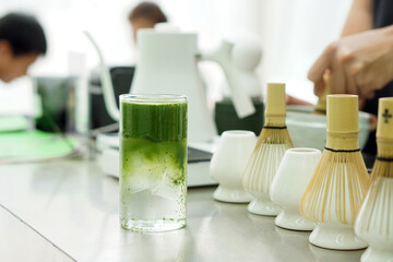 Iced pure matcha green tea - A glass of green tea with water on the table android copy space.