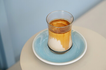 Dirty Coffee - A glass of espresso shot mixed with cold fresh milk on blurred background and copy space.