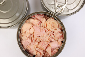 Tuna fish meat flaky chunk in tin can on white background