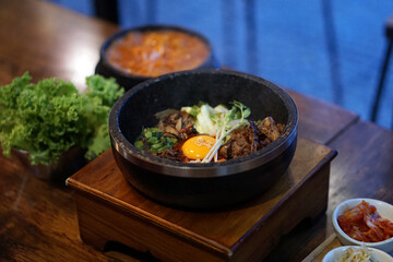 Dolsot bibimbap - Korean mixed rice, Include steamed rice, vegetables, pork and fried egg on top, served in a hot stone pot.