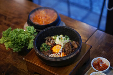 Dolsot bibimbap - Korean mixed rice, Include steamed rice, vegetables, pork and fried egg on top, served in a hot stone pot.