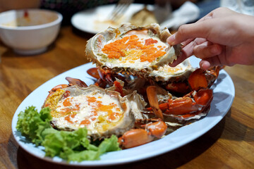 Boiled crab egg with milk - A plate of steamed black crab with crab's spawn (roe) and claw.