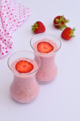 Strawberry smoothie in glass on white background