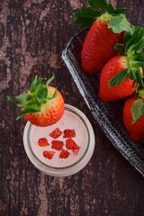 Fresh organic strawberry smoothie in a jar on wooden background