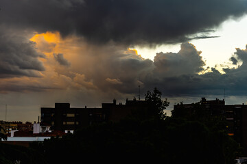 Beautiful dramatic stormy clouds at sunset over silhouette of the city. Cumulonimbus cloud