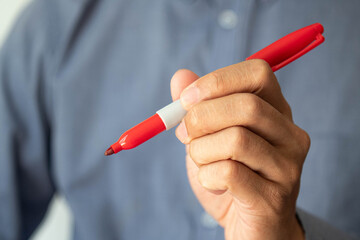 Business concept. Businessman holding red marker. Copy space