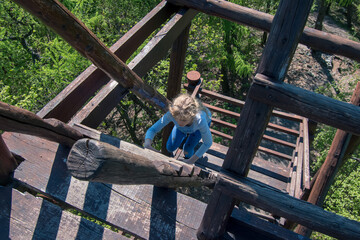 climbing up by wooden steps in the natural observation tower
