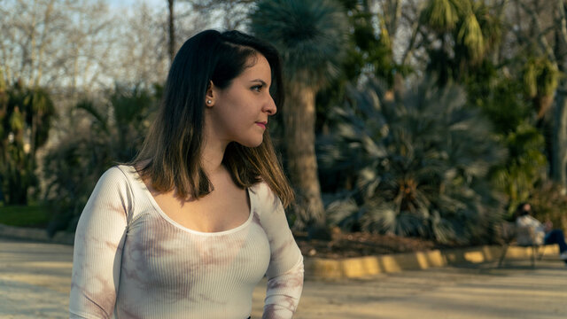 Chica con blusa blanca y fondo desenfocado posando