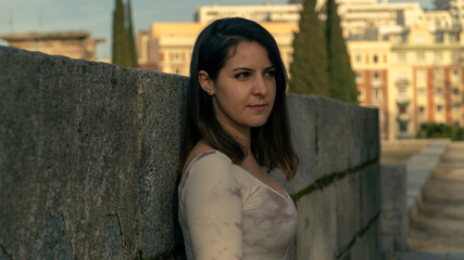 Chica con blusa blanca y fondo desenfocado posando