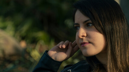 Rostro de mujer joven mirando al frente con la mano en la cabeza