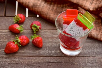 Homemade Vegan Strawberry Chia Coconut Milk Popsicles on wooden table. Summer dessert