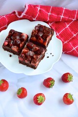 Strawberry chocolate brownies with fresh strawberry and chocolate sauce
