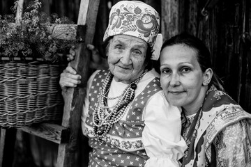 Old and young women in ethnic clothing. Black and white photo.