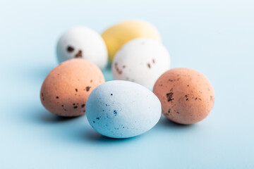 Colorful chocolate easter eggs. Sweet candy eggs on blue background.