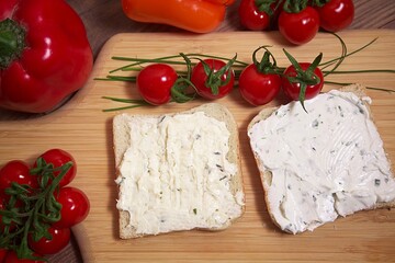 toast bread with tomato and pepper spread and chives on a wooden board