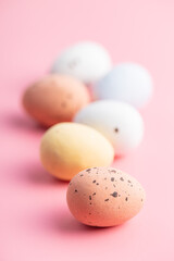Colorful chocolate easter eggs. Sweet candy eggs on pink background.