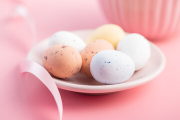 Colorful chocolate easter eggs. Sweet candy eggs on pink background.