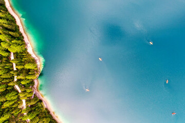 Boote aus der Luft. Luftaufnahme eines Sees in Italien. Sommerlandschaft mit klarem Wasser an einem sonnigen Tag. Draufsicht auf das Boot von einer Drohne aus. Die Wolken spiegeln sich im Wasser