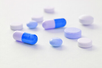 Fototapeta na wymiar White and blue pills on a white background 