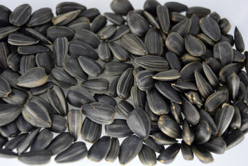 Delicious fried black sunflower seeds fastened into plastic containers and interesting lighting. 
