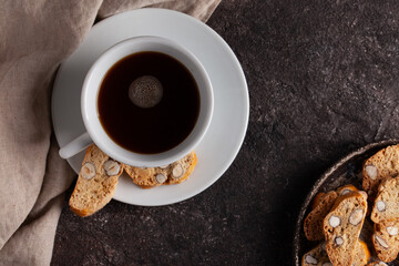 italian cantuccini cookies on concrete table with cup of black coffee.