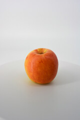 Little ripe yellow apple with red sideways located on a white background. 