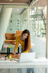 Start up successful small business owner, a freelance young Asian female merchant preparing a package box to deliver to customers, SME entrepreneurs, online business ideas, bloggers