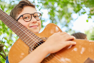 Smiling boy as a music talent with guitar