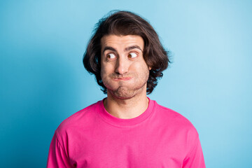 Portrait of childlike arab young man hold air mouth look empty space wear pink cloth isolated on blue background