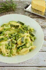 Pasta spaghetti with fresh peas, zucchini, thyme and parmesan cheese
