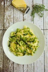 Pasta spaghetti with fresh peas, zucchini, thyme and parmesan cheese
