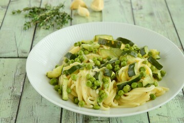 Pasta spaghetti with fresh peas, zucchini, thyme and parmesan cheese
