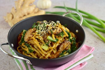 Stir-fried egg noodles with shiitake mushroom and bok choy garnish with white and black sesame seeds