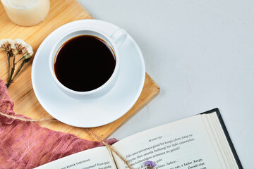 Book with cup of coffee on the wooden board