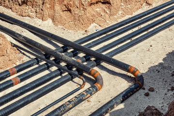 Metal technological pipelines in a trench in the middle of the steppe