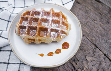 Fresh homemade Waffles in a plate  on a wooden table.