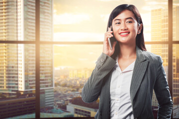 Asian businesswoman standing and talking on the mobile phone