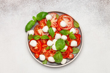 Italian caprese salad with tomatoes, mozzarella cheese and basil leaves. Top View.