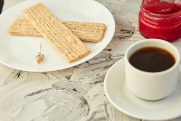 Crispbread with jam for Breakfast on a gray background. A jar of Fresh Honey with foam is next to a Cup of coffee. A minimum of calories. proper nutrition