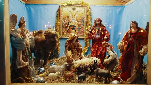 Christmas Manger scene with figurines including Jesus, Mary, Joseph, sheep and magi. Nativity scene with hand-colored figures made out of wood