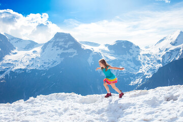 Fototapeta na wymiar Child hiking in mountains. Kids in snow in spring.