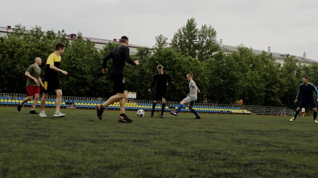 Guys play soccer and give a pass to each other. Football amateur game in a small stadium. Workout training. Team friendly match. Sport