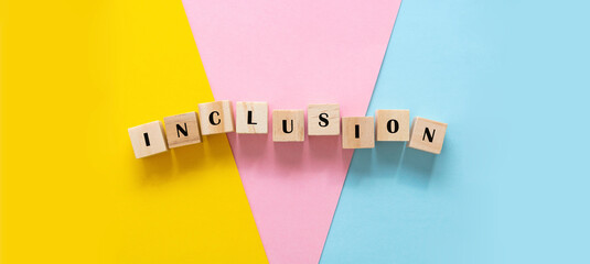 Inclusion text banner wooden cubes on colorful yellow, blue, pink background