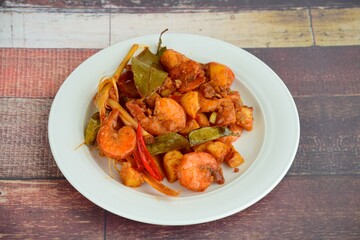 Sambal goreng kentang udang. Fried cubed potato with prawns cooked with coconut milk and spices (Indonesian food)