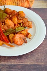 Sambal goreng kentang udang. Fried cubed potato with prawns cooked with coconut milk and spices (Indonesian food)