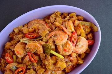 Sambal goreng kentang udang. Fried cubed potato with prawns cooked with coconut milk and spices (Indonesian food)