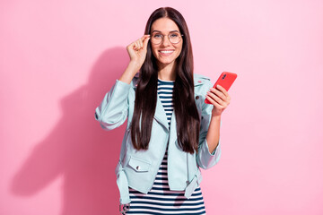 Photo of happy positive young woman hold smartphone glasses isolated on pastel pink color background